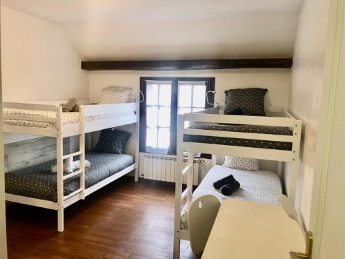 une chambre avec deux lits superposés et une table dans l'établissement Maison Victoria, à Grisy-Suisnes
