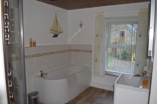 baño con 2 lavabos, bañera y ventana en Troedyrhiw Bed & Breakfast en Cardigan