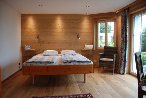 sypialnia z łóżkiem i drewnianą ścianą w obiekcie Jobin Brienz w mieście Brienz