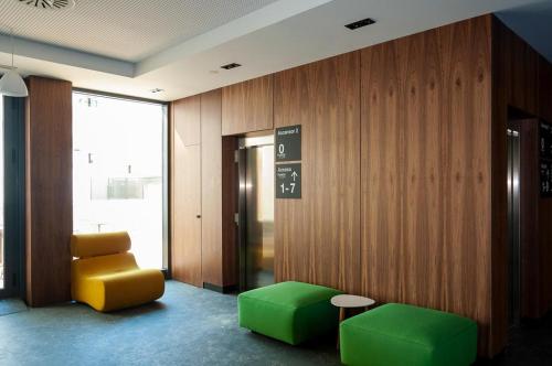 a lobby with green and yellow furniture and a elevator at Apartamentos 2H LIVING in León