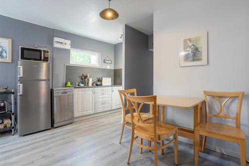 une cuisine avec une table, des chaises et un réfrigérateur dans l'établissement L' Eclose Ty Gwen, au Guilvinec