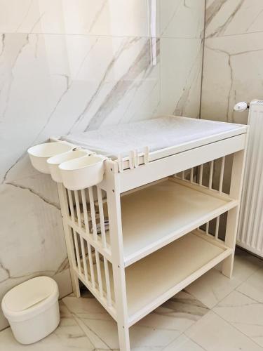 a white bathroom with a toilet and a shelf at Franco Piešťany Apartments 2 in Piešťany