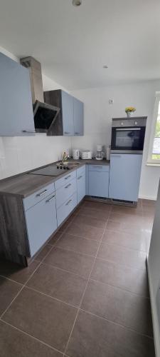 a kitchen with white cabinets and a tile floor at Möblierte 3-Zimmerwohnung in Weißenfels nahe Leuna, Leipzig mit WLAN und Waschtrockner in Weißenfels
