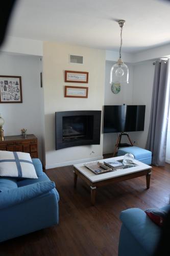 un salon avec un canapé bleu et une table basse dans l'établissement maison 3 chambres spa centre Morgat, les plages et les restaurants a pied, à Crozon