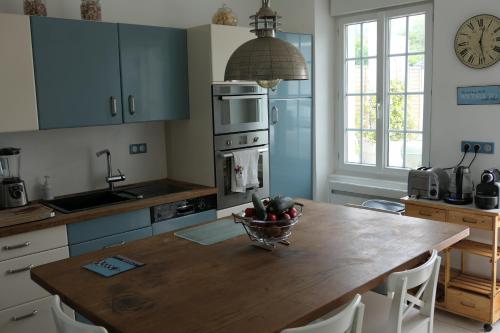 une cuisine avec une table avec un bol de fruits dessus dans l'établissement maison 3 chambres spa centre Morgat, les plages et les restaurants a pied, à Crozon