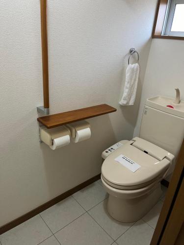 a bathroom with a toilet in a room at サンムーン鶴間 in Yamato