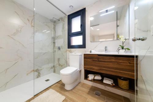 a bathroom with a toilet and a glass shower at Cosy Casa Valentino in Orihuela Costa