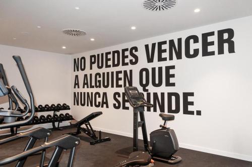 a gym with a sign on the wall at Apartamentos 2H LIVING in León