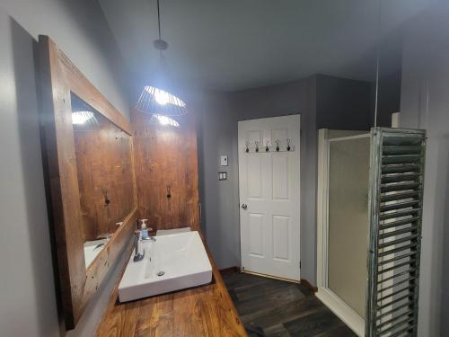 a bathroom with a sink and a mirror at 3CH - Bord de lac & Spa, foyer, billard, AC et plus in Hébertville