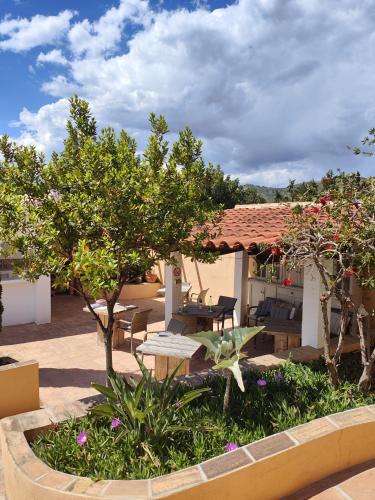 een terras met een tafel, stoelen en bomen bij Finca Sol y Cielo in Cajís