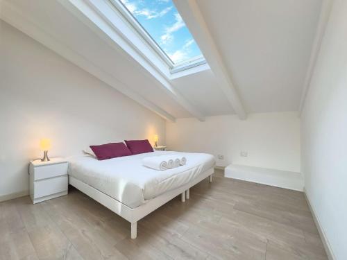 - une chambre blanche avec un lit et une lucarne dans l'établissement Tony Allard By Winsome Destination 4B, à Cannes