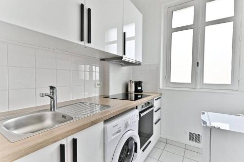 une cuisine blanche avec un évier et un lave-vaisselle dans l'établissement Appartement Arc de Triomphe - Neuilly - III, à Neuilly-sur-Seine