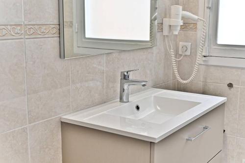 La salle de bains est pourvue d'un lavabo blanc et d'un téléphone. dans l'établissement Appartement Arc de Triomphe - Neuilly - III, à Neuilly-sur-Seine