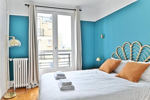 - une chambre bleue avec un grand lit et des serviettes dans l'établissement Appartement Arc de Triomphe - Neuilly - III, à Neuilly-sur-Seine