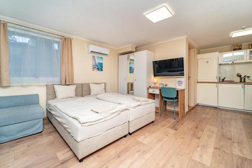 a bedroom with a bed and a desk and a tv at Palmy Apartmanhouse Maglód in Maglód