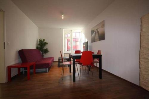 a living room with a table and red chairs at HITrental Oerlikon Apartments in Zürich