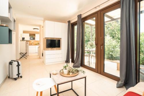 a living room with a table and a tv at VSG Resort - Apartments 200m from Beach, Pool, Sauna & Jacuzzi in Klimno