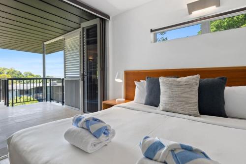 a bedroom with a large bed and a balcony at Panoramic Ocean Penthouse in Noosa Heads