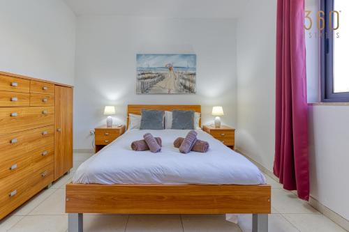ein Schlafzimmer mit einem Bett mit zwei Kissen darauf in der Unterkunft Lovely 1BR Apt with private balcony in Gzira by 360 Estates in Gżira
