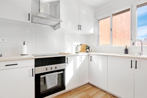 a white kitchen with white cabinets and a sink at Apartamento 4 habitaciones y 2 baños in Puerto de Sagunto