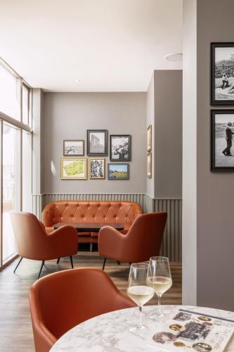 a restaurant with orange chairs and a couch at Carnoustie Golf Hotel 'A Bespoke Hotel’ in Carnoustie