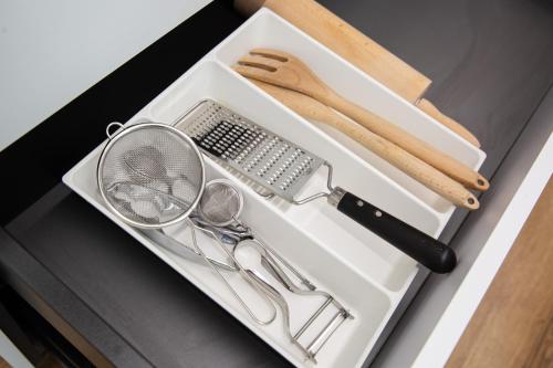 a white drawer with a comb and scissors and other kitchen utensils at Piso Andorra Arinsal in Arinsal
