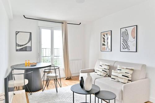 un salon blanc avec un canapé et une table dans l'établissement Appartement spacieux Proche de la capitale - II, à Montreuil