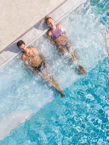 two people are swimming in a swimming pool at LA BASTIDE DU SOLEIL avec piscine, calme, randonnée à proximité in Allegre Les Fumades
