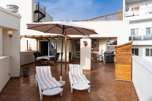 a patio with two chairs and an umbrella at Apartment happy place mit Meerblick in Alcalá