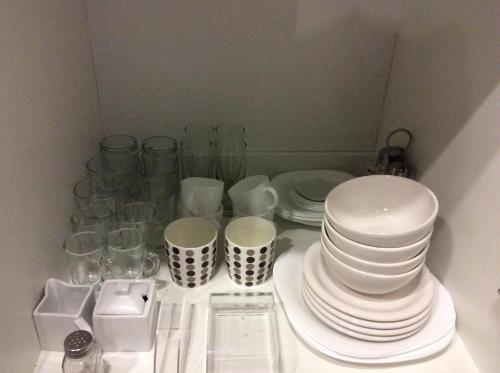 un grupo de platos y tazas sentados en una mesa en Linda Bay spa playa Unidad 603 Mar de Las Pampas, en Mar de las Pampas