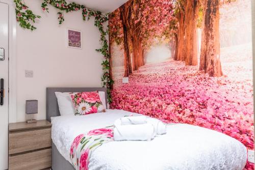 a bedroom with a wall covered in pink flowers at Blossom Retreat in Northampton