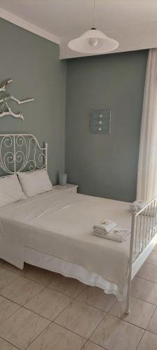 a bedroom with a white bed with a blue wall at Seaside Studios in Paralia Dionysiou