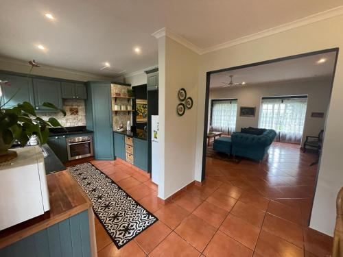 a kitchen and a living room with a blue couch at Lavender Cottage in Hillcrest