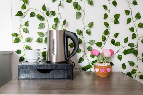 a coffee pot on a table with a plant at Blossom Retreat in Northampton