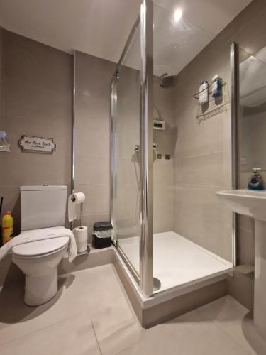 a bathroom with a shower and a toilet and a sink at MPL Ensuites with kitchenettes Suites - Leeds City - Netflix & WIFI- First Direct & 02 Arena- LGI Hospital & Uni 5 Mins in Leeds