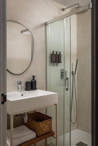 un bagno con lavandino e doccia di BYPILLOW Casa Gades a Cadice