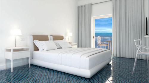 a white bedroom with a bed and a balcony at Hotel Belair in Sorrento