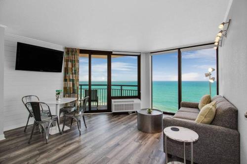 a living room with a couch and a table at Enjoy Luxurious Oceanfront King Suite! Dogs OK! 1406 in Myrtle Beach