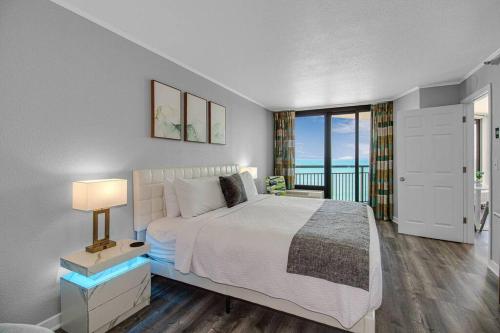 ein Schlafzimmer mit Bett und Blick auf das Meer in der Unterkunft WINTER RATES! Enjoy Luxurious Oceanfront King Suite! Dogs OK! 1406 in Myrtle Beach
