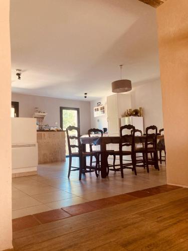 a dining room and kitchen with a table and chairs at Maison avec jardin dans village in Réaup