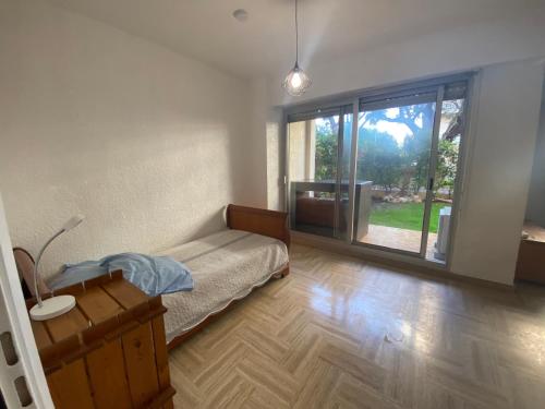 une chambre avec un lit et une grande fenêtre dans l'établissement Cros de Cagnes Pins Sud Évasion, à Cros-de-Cagnes