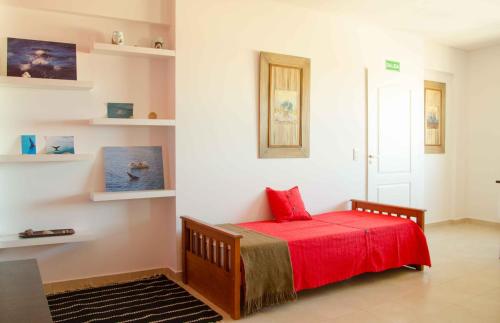 a bedroom with a bed with a red blanket at Las Anémonas Centro in Puerto Madryn