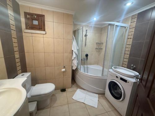 a bathroom with a toilet a sink and a washing machine at Corner splash in Ankara