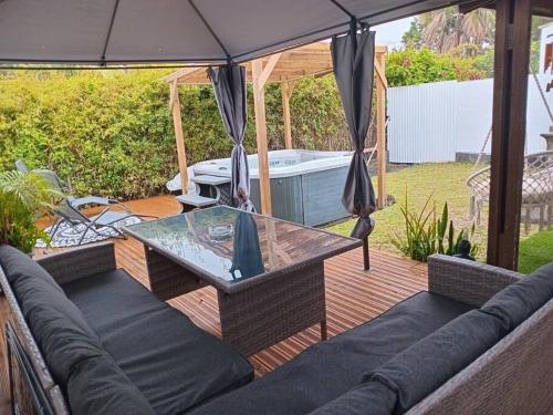 a patio with a glass table and an umbrella at Caz A Mwa in Saint-Joseph