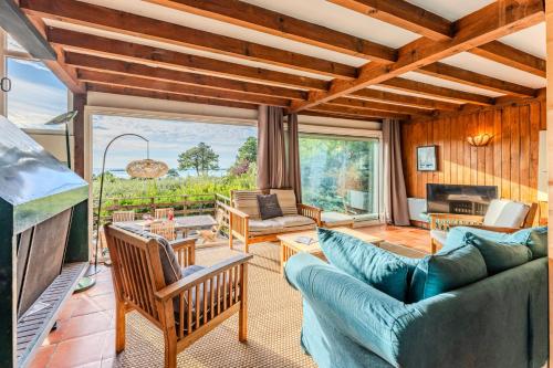 Elle comprend un salon meublé et une grande fenêtre. dans l'établissement Villa Diomedea - Welkeys, à La Teste-de-Buch