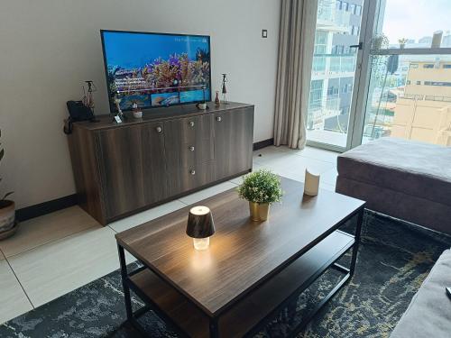 ein Wohnzimmer mit Fernseher und Couchtisch in der Unterkunft Skynest Residences by Lisa's Paradise D in Nairobi