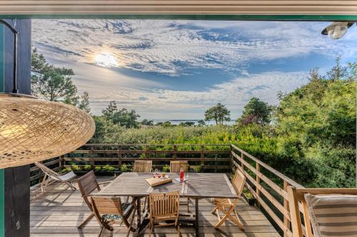 un patio avec une table et des chaises sur une terrasse dans l'établissement Villa Diomedea - Welkeys, à La Teste-de-Buch