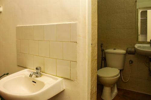 a bathroom with a sink and a toilet at Summer Hostel in Palolem