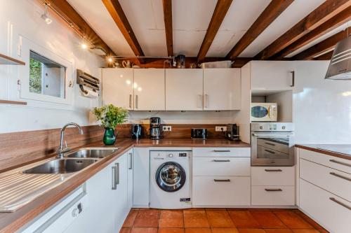 une cuisine avec des armoires blanches et un évier dans l'établissement Villa Diomedea - Welkeys, à La Teste-de-Buch