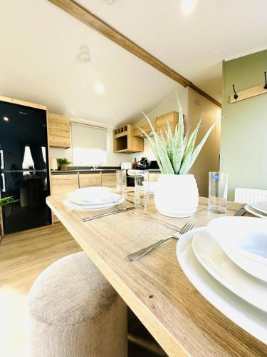 a kitchen with a wooden table with white dishes on it at Moor Crest in Scarborough